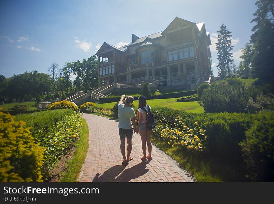 Photo of Couple Standing Outside the House