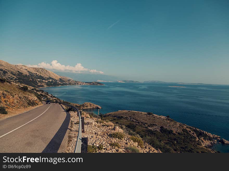 Empty Road Near Calm Body of Water