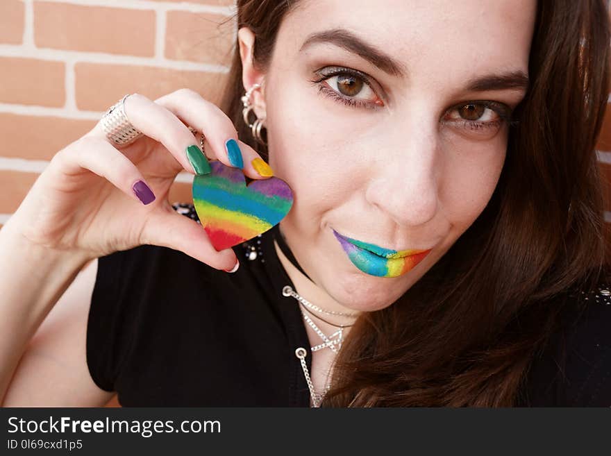 Woman Wearing Black Shirt Holds Striped Heart Decor