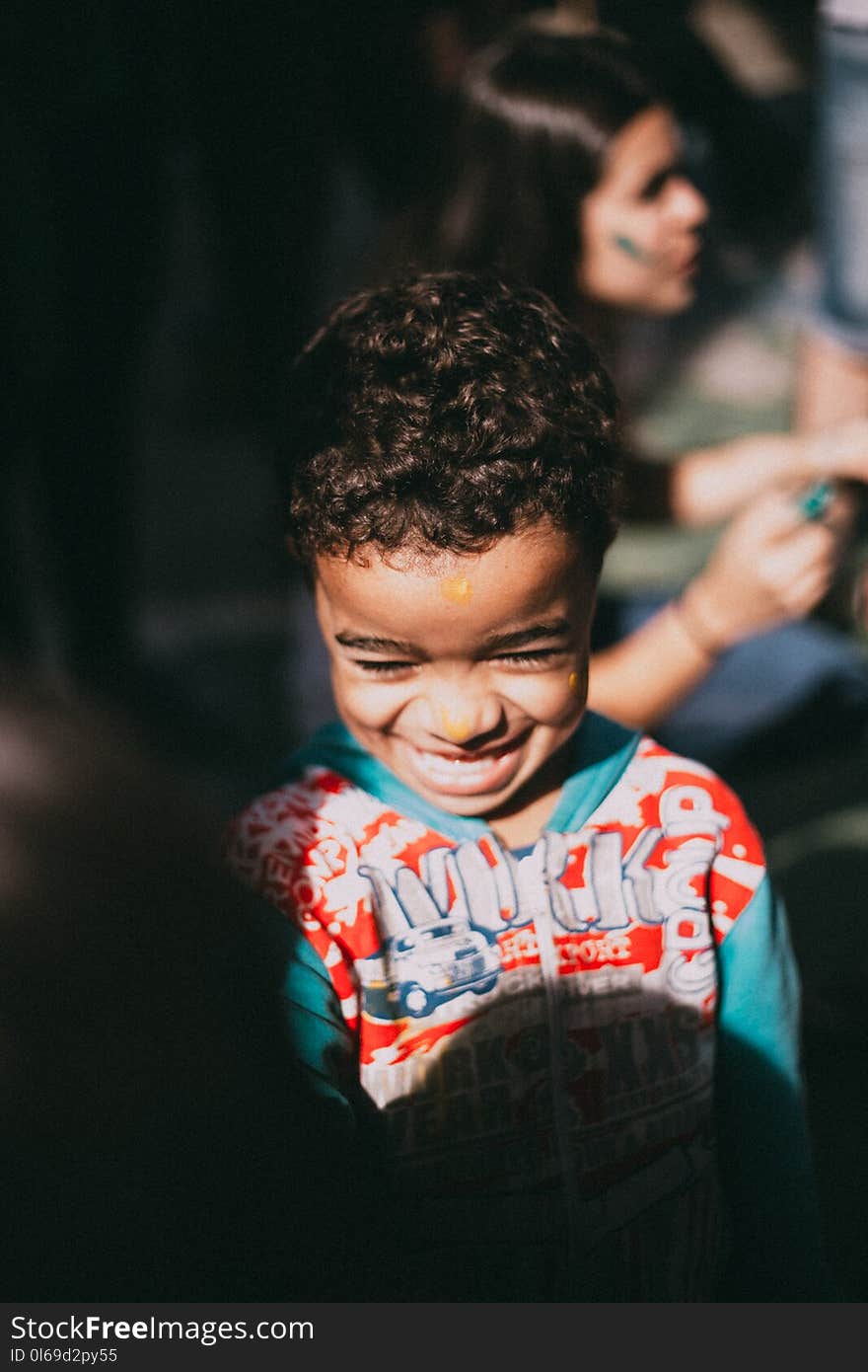 Selective Focus Photography of a Boy Who Were Smiling in With Red and Blue Hooded Jacket