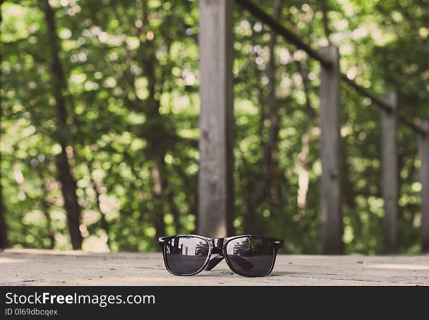 Black Framed Wayfarer-style Sunglasses on Floor