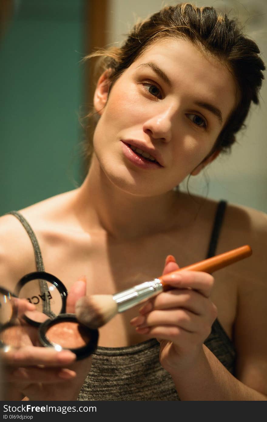 Woman Holding Highlighter and Makeup Brush