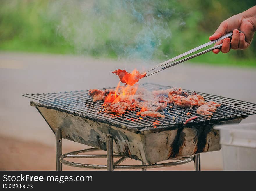 Person Holding Tongs Ccoking Barbecue