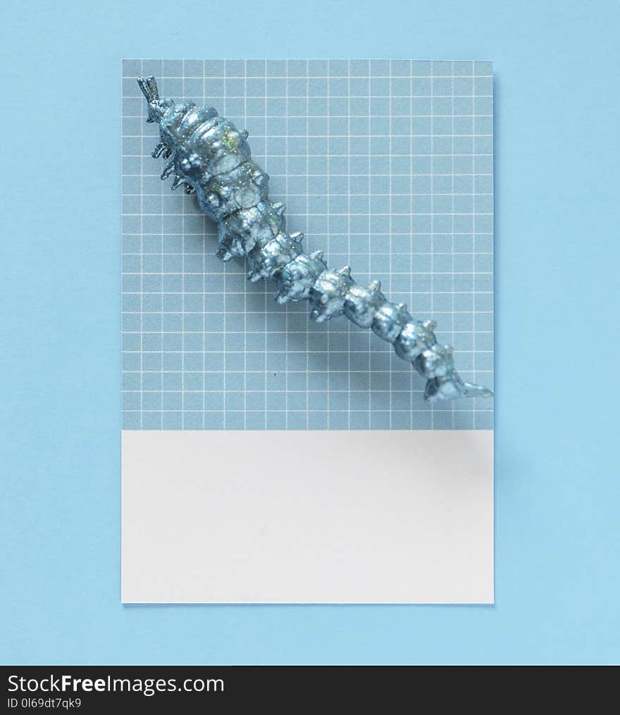 Photo of Caterpillar Figurine on Top of Blue and White Gingham Tile