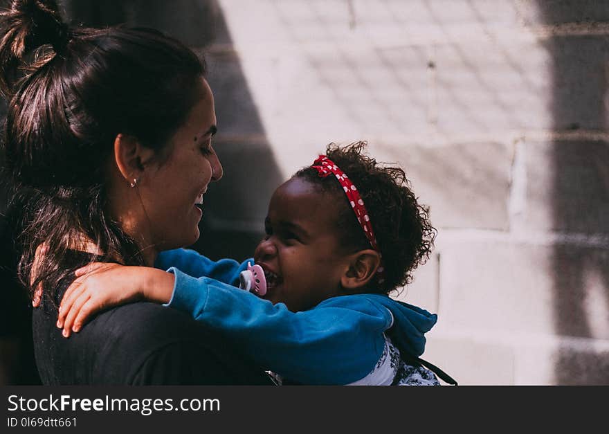 Woman Holding Baby Wearing Blue Jacket