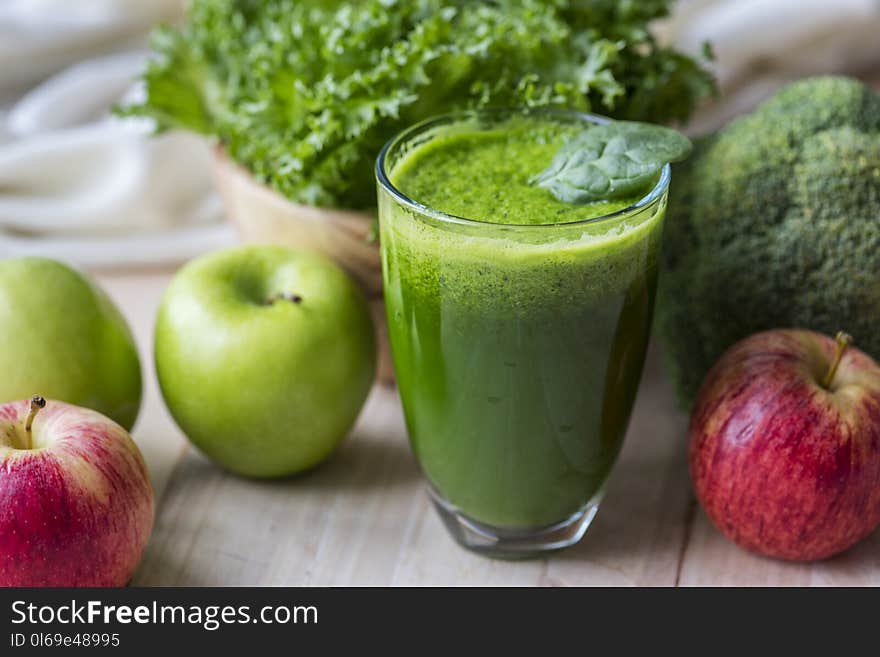 Green Liquid Fruit Juice on Glass Beside Apples