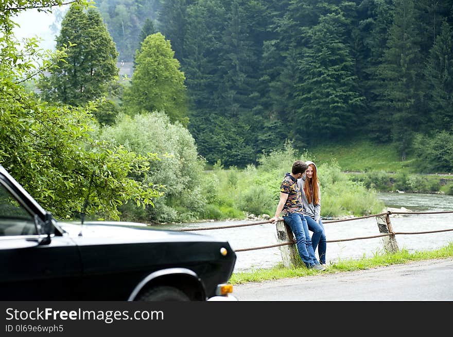 Man and Woman Sitting on Road Gutter