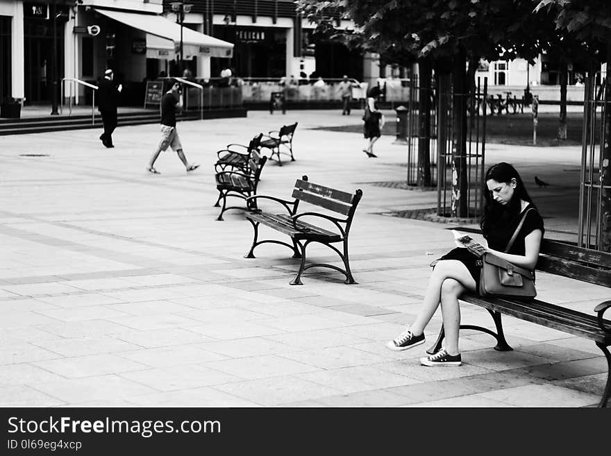 Grayscale Photography of Woman Sitting While Reading Book