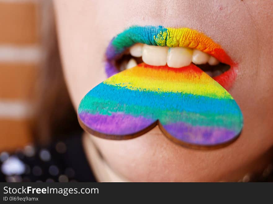 Person Biting Multicolored Heart Decor