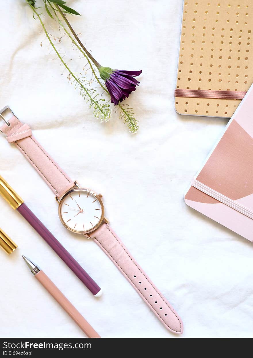 Flat lay Photography of Watch Near Pens and Notebook