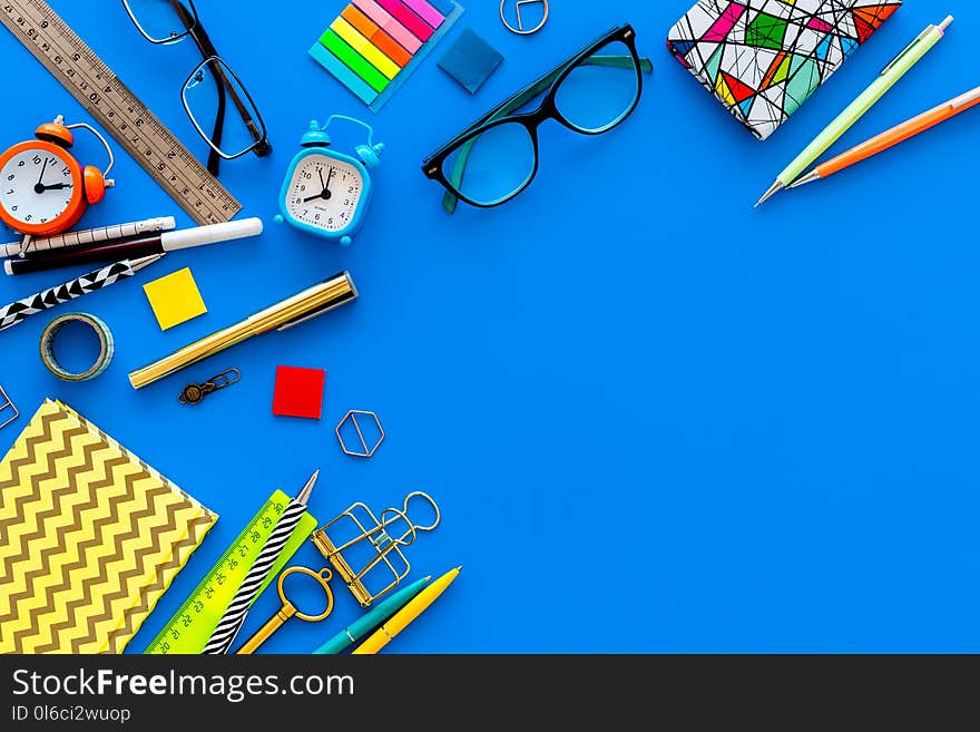 Education Concept. Stationery Frame With Glasses And Notebook On Blue Background Top View Copy Space