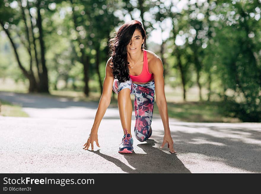 Young sportswoman stretching and preparing to run.