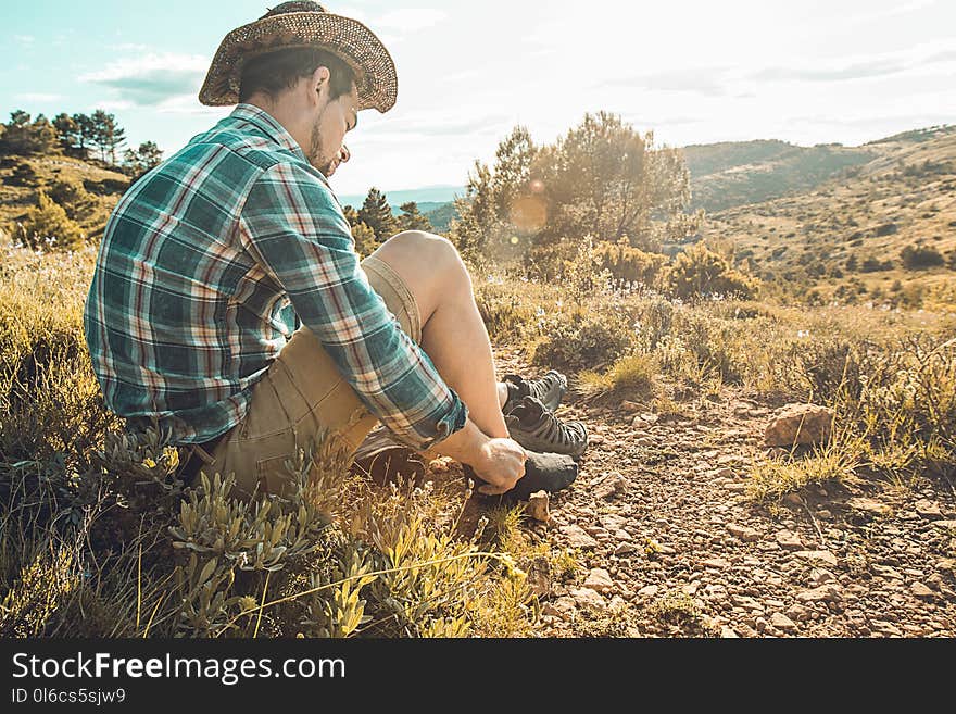 Man Tying His Boots On The Mountain