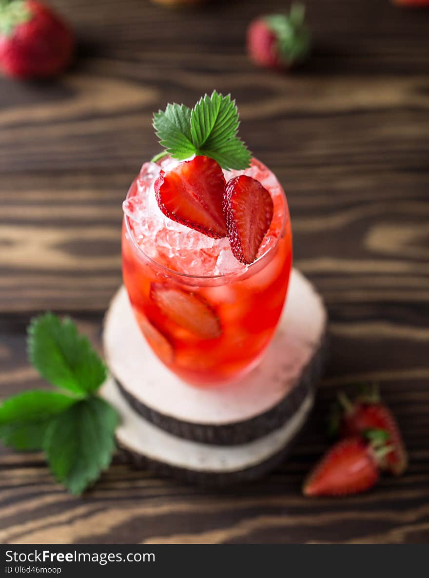 Fresh strawberry cocktail. Fresh summer cocktail with strawberry and ice cubes. Glass of strawberry soda drink on dark background.