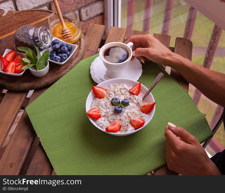 Fitness woman have a breakfast. Healthy Homemade Oatmeal with Berries.