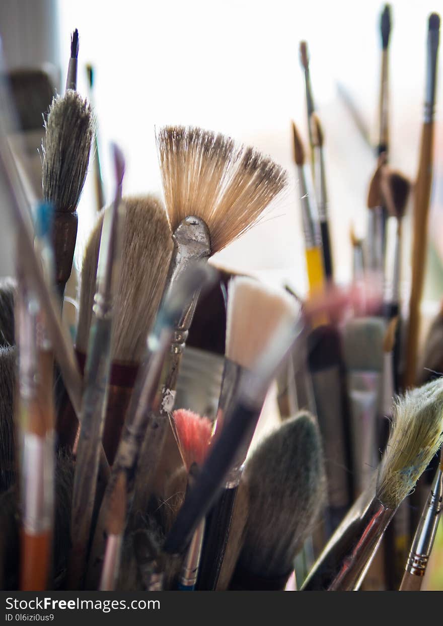 Close up of a variety of used painter brushes