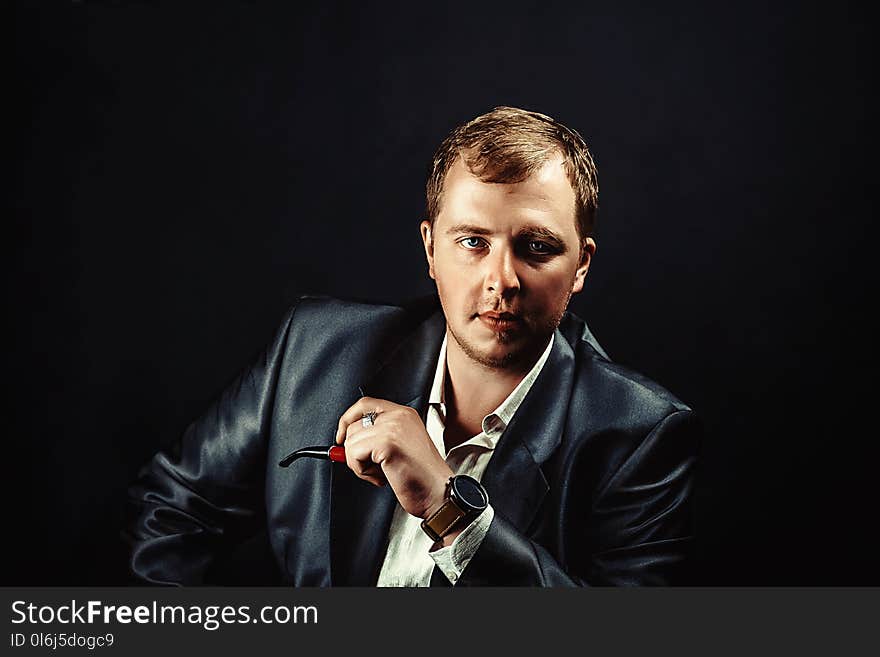 Elegant young man in suit Smoking a pipe. Elegant young man in suit Smoking a pipe