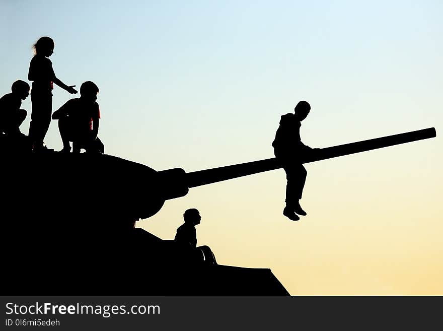 Silhouettes of children climbing the tank