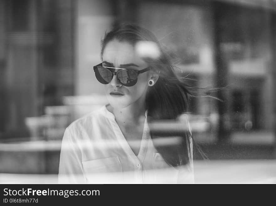 Grayscale Photo of Woman through a glass window