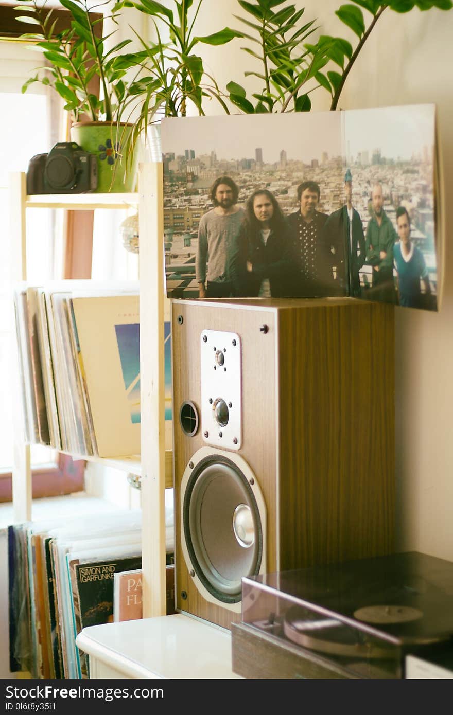 Photo of Group of Men on Top of Brown Speaker