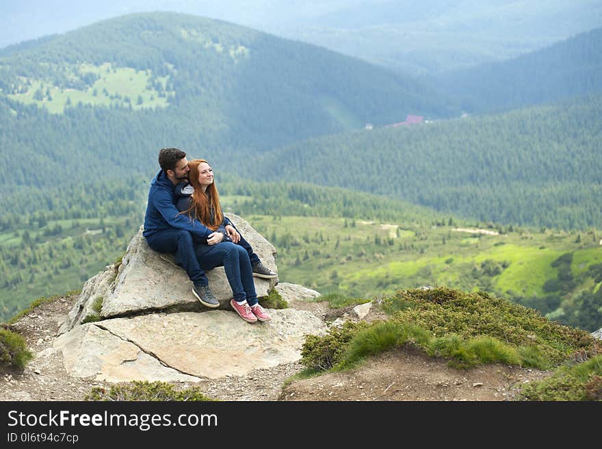 Photo of Couple Sitting on Rock