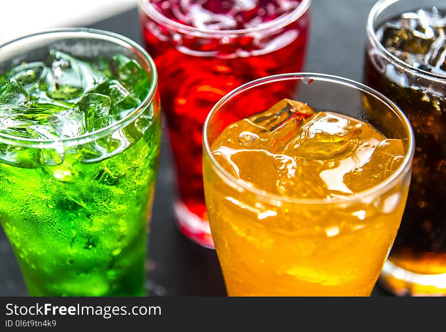 Four Clear Drinking Glasses Filled With Beverages