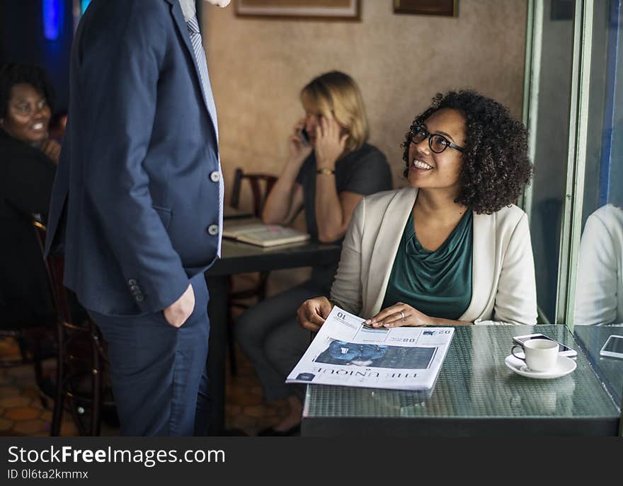 Man in Blue Suit Jacket in Front of Woman Sitting Near Window