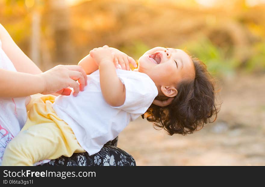 Person Carrying Child Wearing White Top