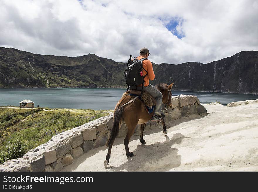 Man carrying a bag pack Riding a Brown Horse