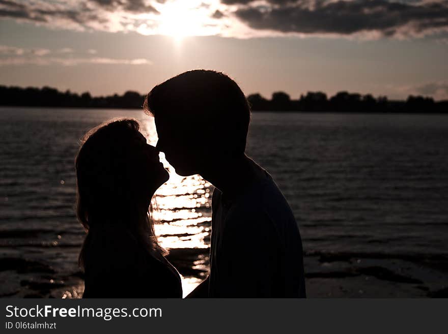 Silhouette Photo of Man and Woman Kissing