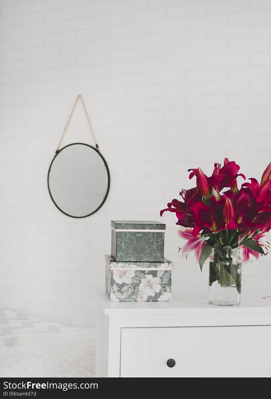 Red Flower Centerpiece on White Wooden Drawer Dresser