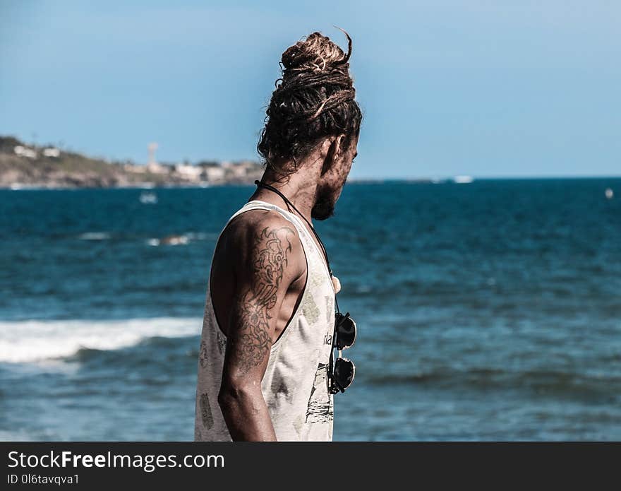 Man in White Tank Top on Seashore