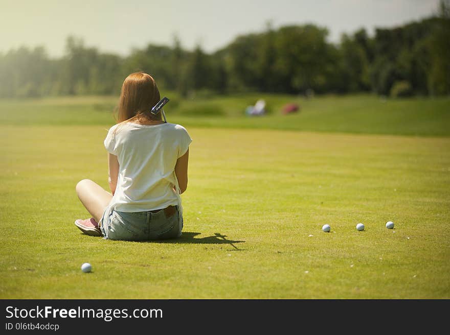 Photo of Woman Sitting on Grass Field