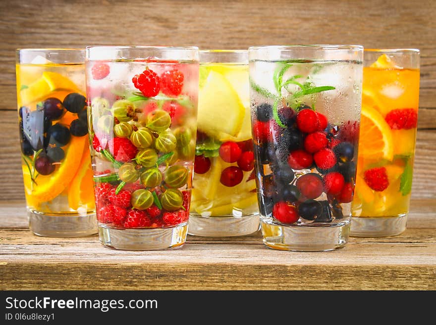 Various detox water in glasses, different tastes, berries, fruits.