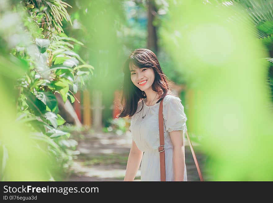 Woman Standing Nearby Green Leafed Plant