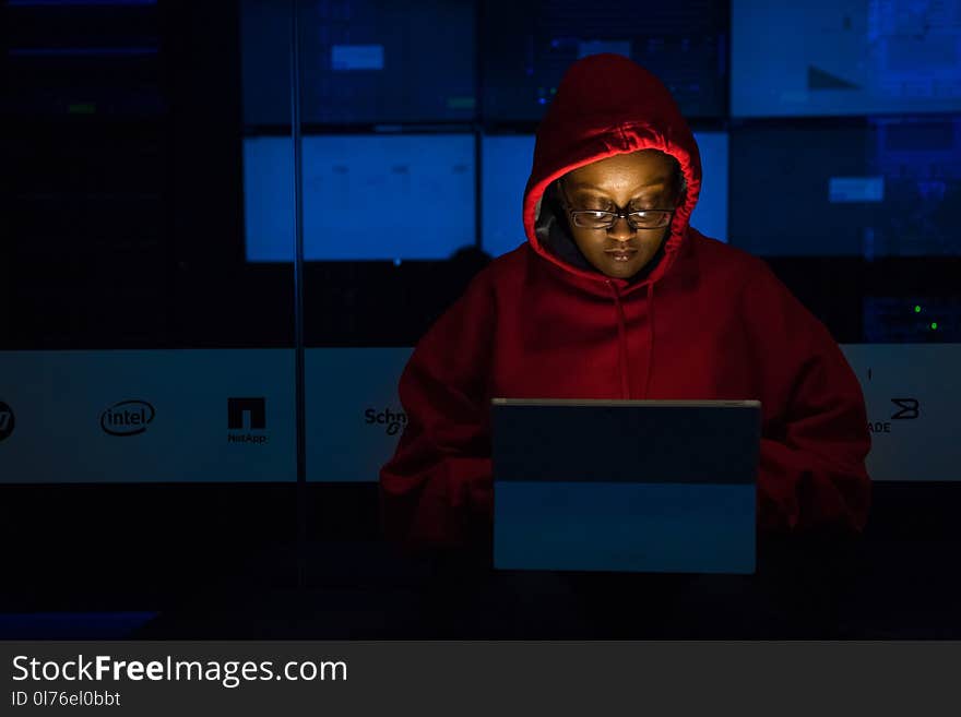 Woman in Red Hoodie Using Gray Laptop Computer