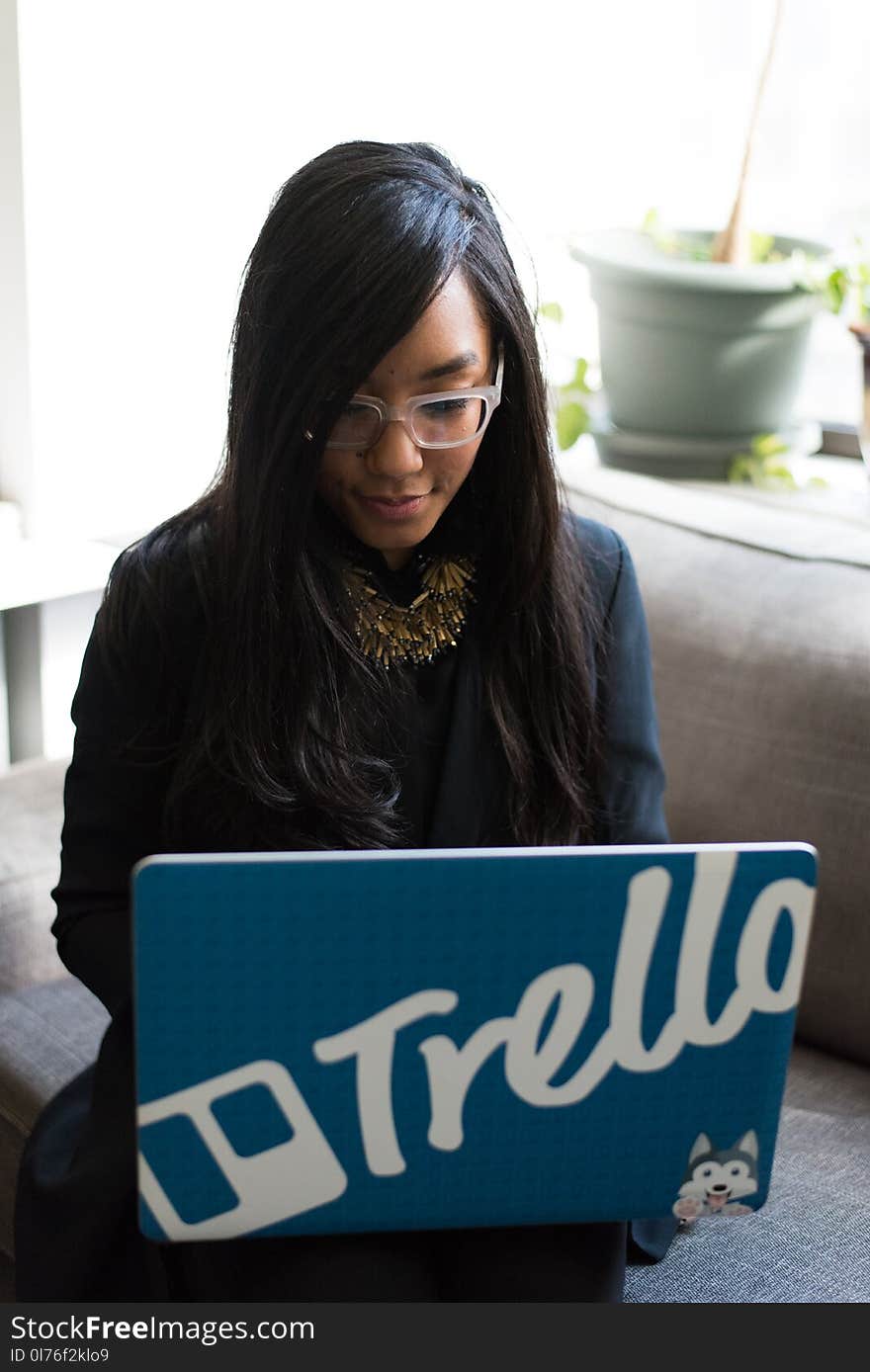 Woman in Black Coat Holding Her Blue Laptop Computer