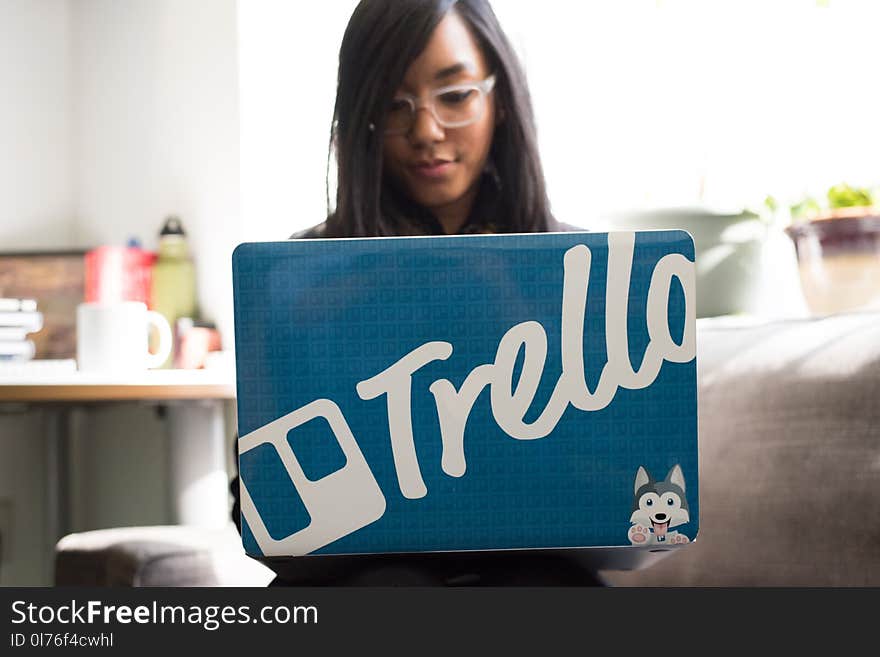 Woman Wearing Eyeglasses Using Blue and and Gray Laptop Inside Room