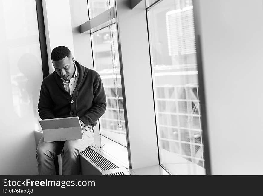 Grayscale Photo of Man Using Laptop