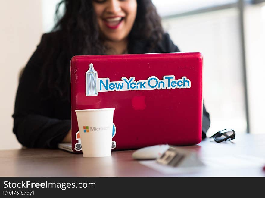 Selective Focus Phot of Woman Typing on Red Macbook