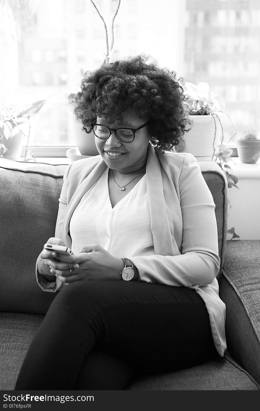 Grayscale Photo of Woman Sitting on Couch