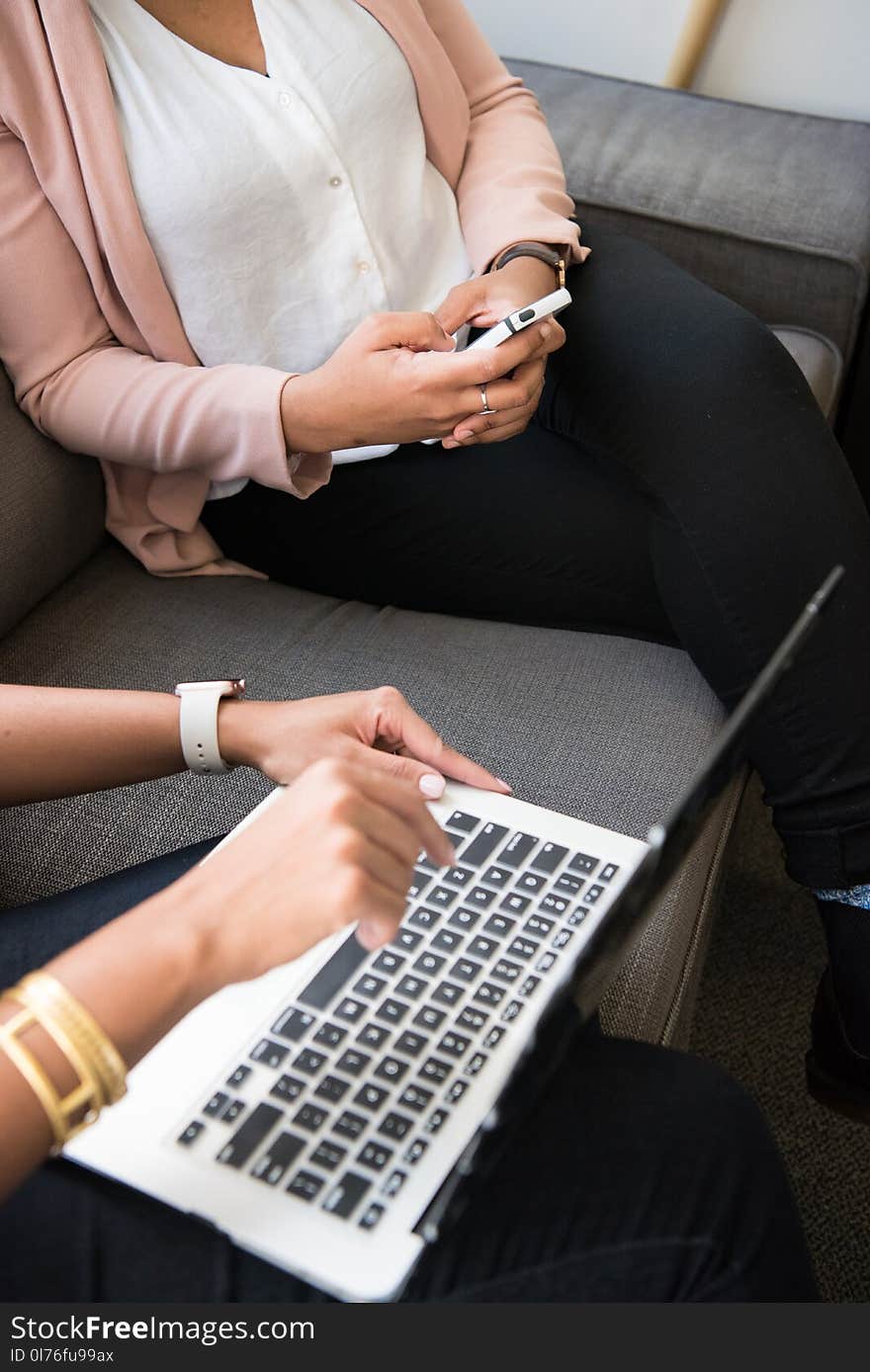 Two Women Using Macbook and Smartphone