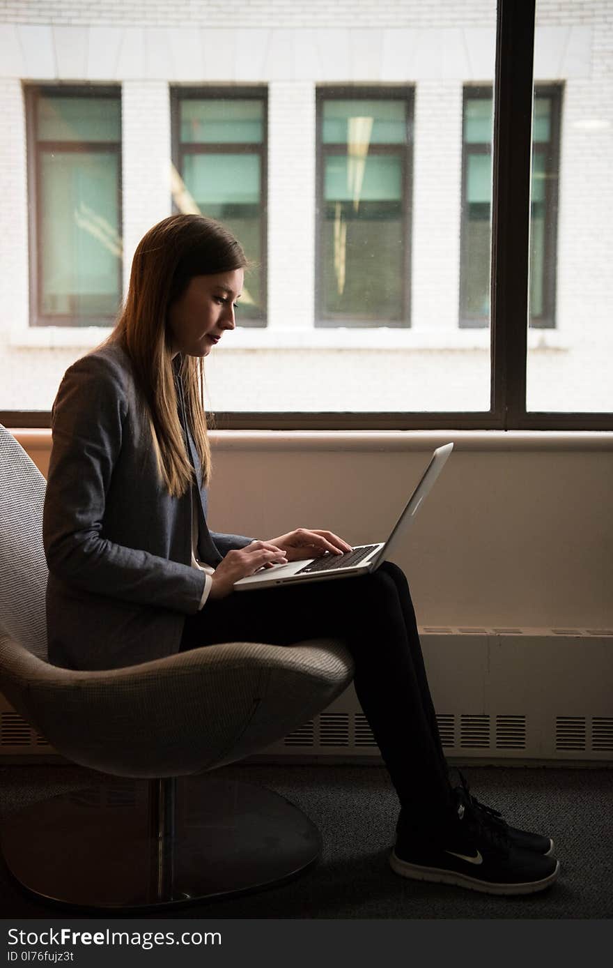 Woman Sits and Use Laptop Computer Near Window