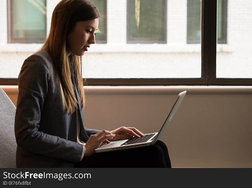 Woman Sitting Down and Using Laptop on Her Lap