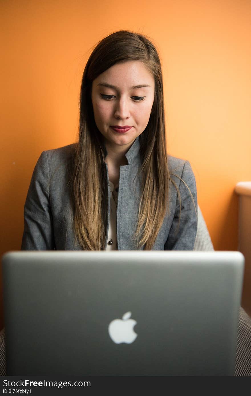 Woman in Gray Suit Coat Using Silver Apple Macbook