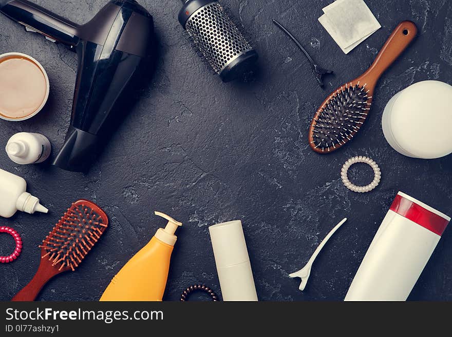 Image of hairdresser accessories, hair dryer, combs, in circle on empty black background