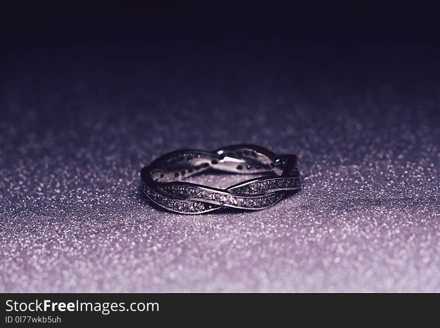 Fashion silver ring over glittering background, macro. Fashion silver ring over glittering background, macro.