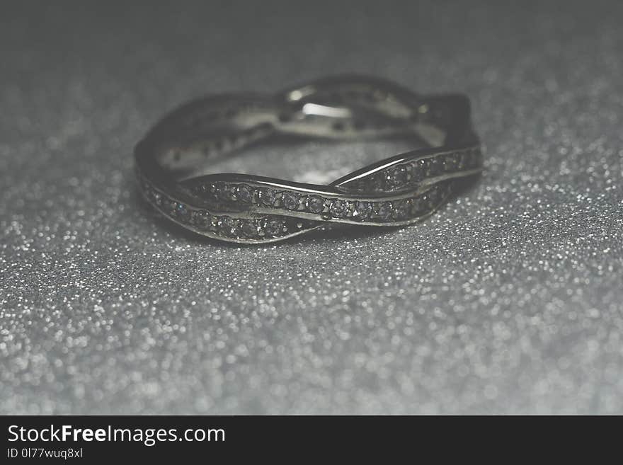 Fashion silver ring over glittering background, macro. Fashion silver ring over glittering background, macro.