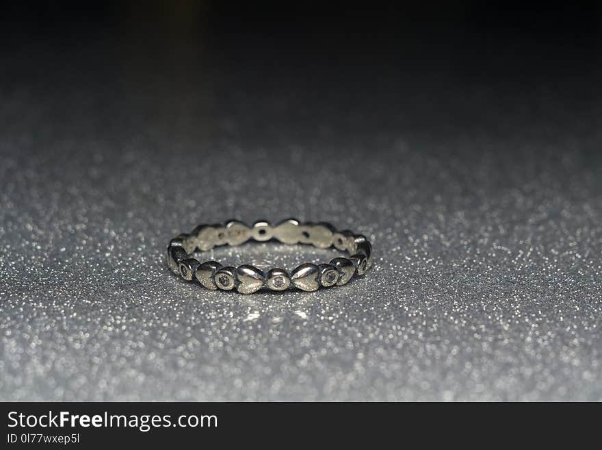 Fashion silver ring over glittering background, macro. Fashion silver ring over glittering background, macro.