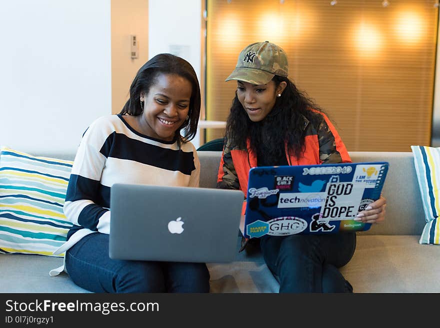 Two Women Holding Laptop